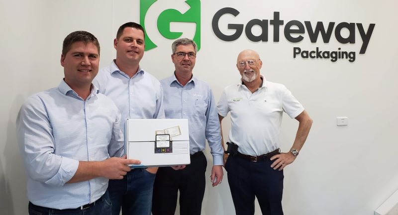 Box Latch - Jim Wilson standing with three men from Gateway Packaging. One is holding a box with a Box latch on it.