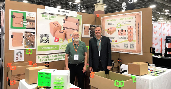 Box Latch - Jim Wilson and Dan Abrahms standing, surrounded by graphics booth at the milwaukee manufacturing technology trade show